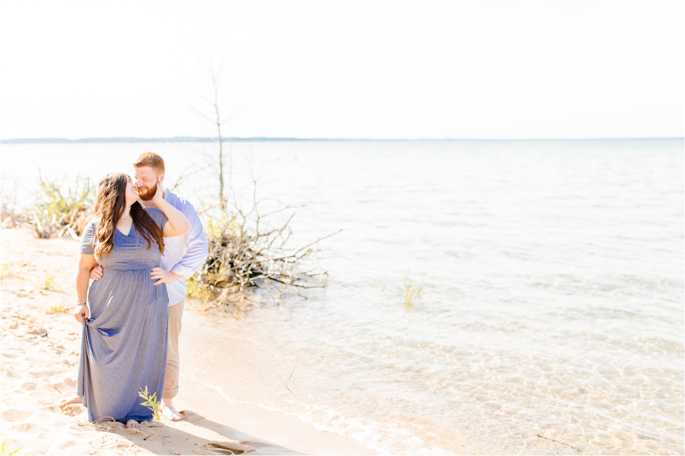 engaged couple on the shoreline in traverse city